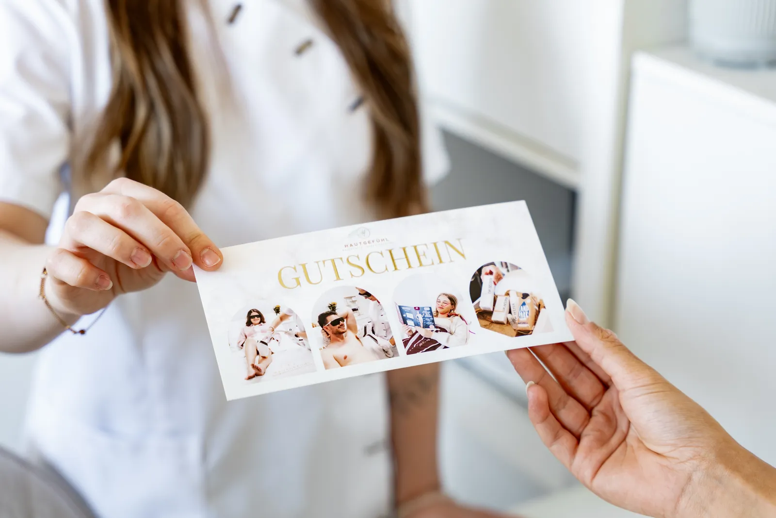 Lara überreicht einen Hautgefühl-Gutschein